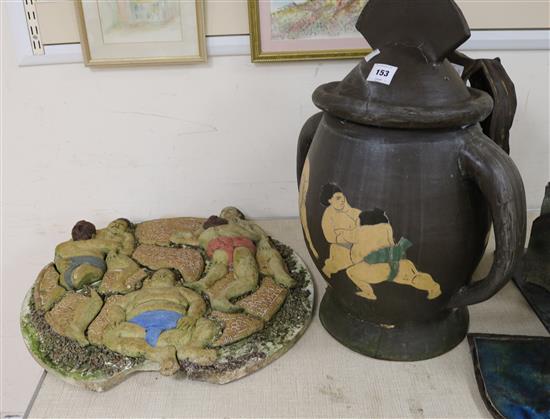 An Art pottery lidded jar decorated with sumo wrestlers and a wall plaque